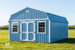 Blue metal barn-style shed with white trim and double front doors, set on a grassy lawn.