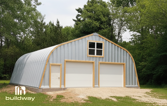 Buildway Quonset Alpine model featuring a curved metal roof with wooden trim, two large garage doors, a side entry door, and an upper window, set against a backdrop of green trees.