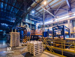 Interior of a large commercial steel facility featuring machinery, pallets, and industrial equipment. Designed for manufacturing, processing, and heavy-duty business operations.