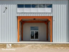 Close-up of an I-beam structure with an orange-framed service door entrance, highlighting reinforced framing and architectural detailing.