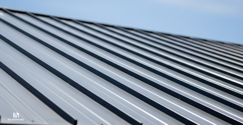 How Long Do Steel Buildings Last If You Ignore Maintenance? The Result Is Brutal 6 Close-up of a standing seam metal roof, showing smooth steel panels with raised seams running in parallel lines across the roof surface.